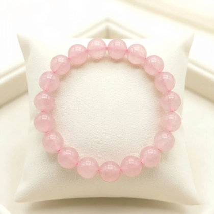 Natural Rose Quartz crystal bracelet featuring polished, translucent soft pink beads on a clear stretch cord from lakshya gems