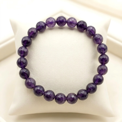 Natural Amethyst crystal bracelet featuring polished, deep purple translucent beads on a stretch cord.