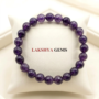 Natural Amethyst crystal bracelet featuring polished, deep purple translucent beads on a stretch cord.