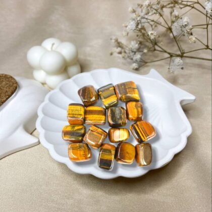 Polished Tiger Eye tumble stones showing golden-brown chatoyant bands for courage and focus.