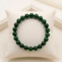 A premium Green Jade bracelet showing various shades of natural forest green with a polished, waxy luster