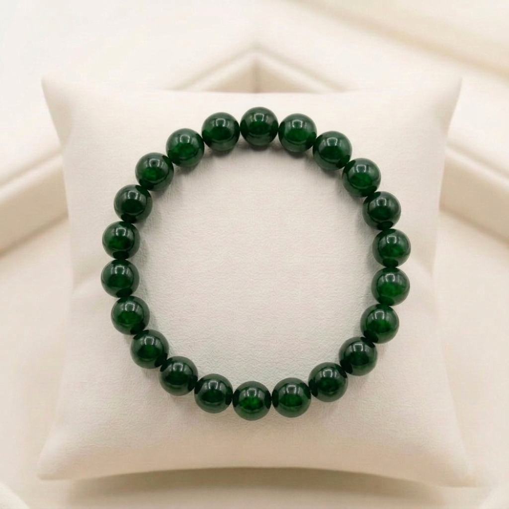A premium Green Jade bracelet showing various shades of natural forest green with a polished, waxy luster