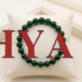 A premium Green Jade crystal bead bracelet showing various shades of natural forest green with a polished, waxy luster