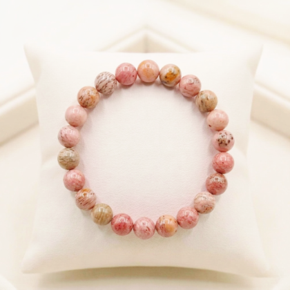 Natural Rhodochrosite crystal bracelet featuring polished raspberry-pink beads with white zig-zag bands from lakshya gems