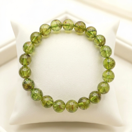 A premium natural peridot crystal bead bracelet showing translucent vibrant lime-green colors and polished finish.