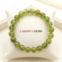 A premium natural peridot crystal bead bracelet showing translucent vibrant lime-green colors and polished finish.