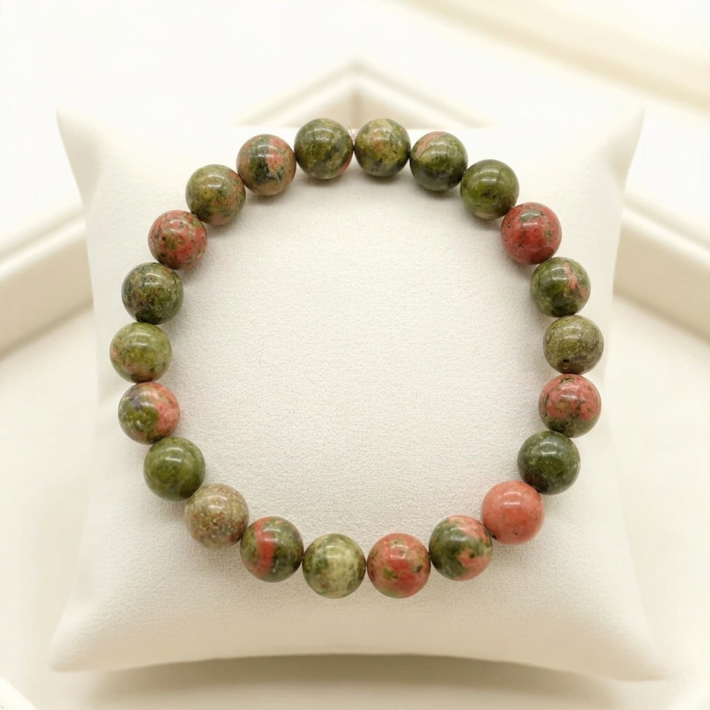 A high-quality Unakite bracelet featuring a natural mottled pattern of olive green and peachy-pink colors.