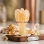 A hand-carved natural Citrine crystal angel showing transparent golden-yellow hues and polished finish.