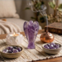 A hand-carved natural Amethyst crystal angel featuring deep purple hues and translucent polished finish.