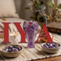A hand-carved natural Amethyst crystal angel featuring deep purple hues and translucent polished finish.