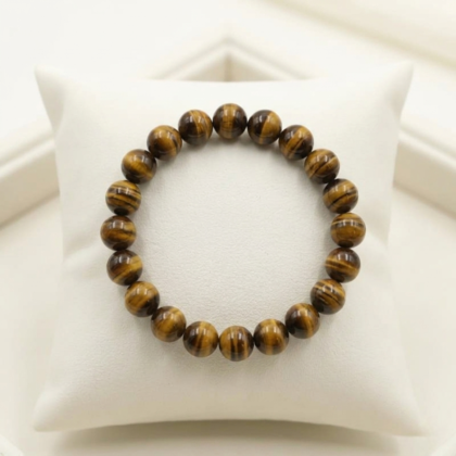 A high-quality Tiger Eye crystal bead bracelet showing vibrant golden-yellow chatoyant bands on a white background.