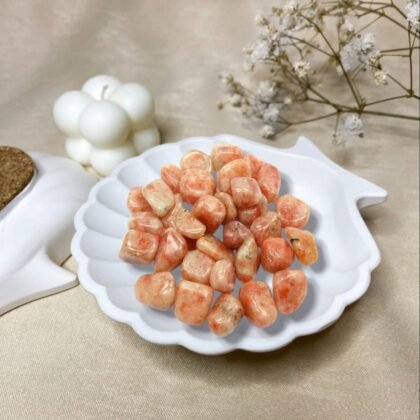 Polished Sunstone tumble stones showing a shimmering orange metallic luster for joy and vitality.
