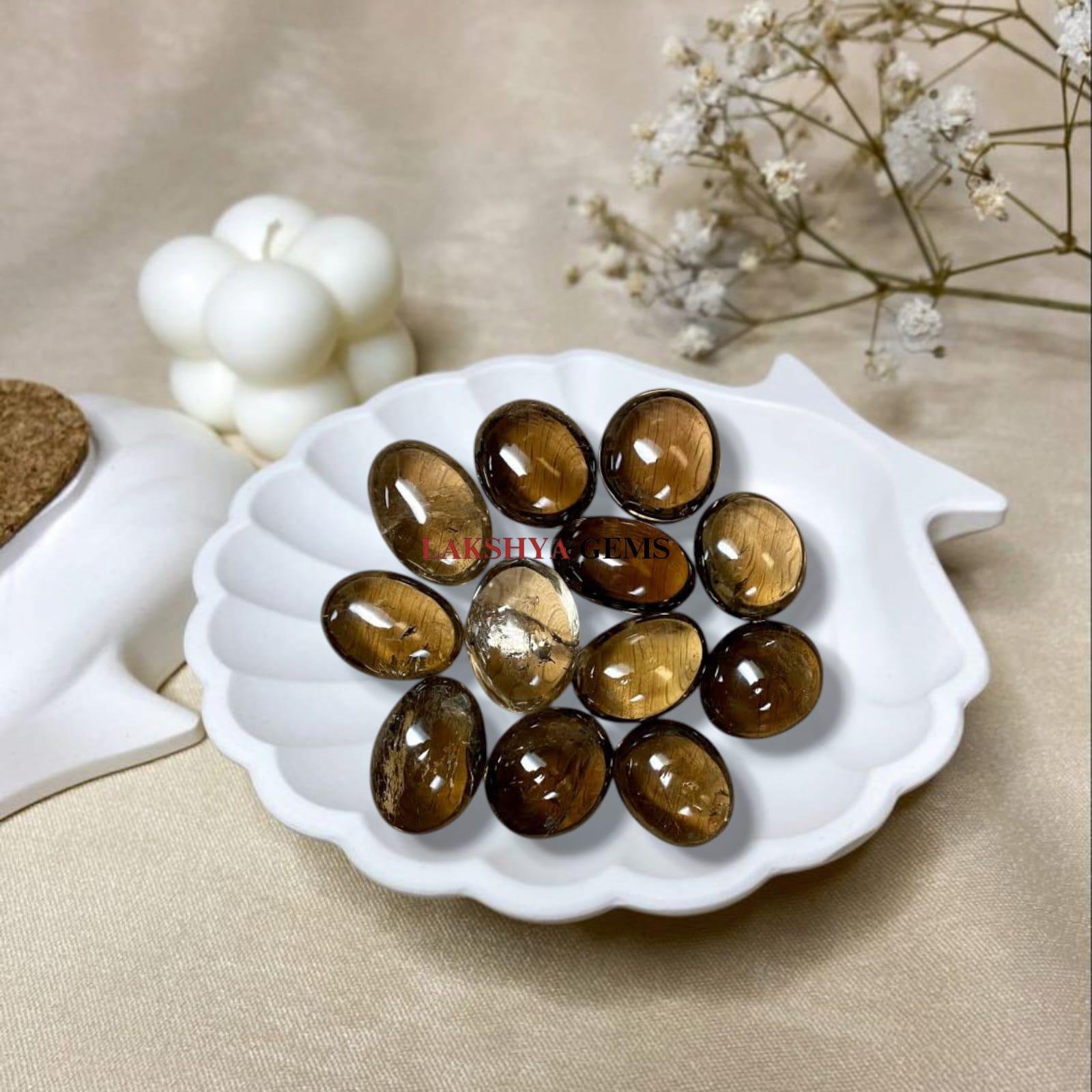 A collection of polished Smoky Quartz crystal tumbles featuring translucent brownish-grey tones and natural clarity from lakshya gems mumbai