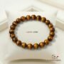 A high-quality Tiger Eye crystal bead bracelet showing vibrant golden-yellow chatoyant bands on a white background.