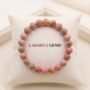 Natural Rhodochrosite crystal bracelet featuring polished raspberry-pink beads with white zig-zag bands from lakshya gems
