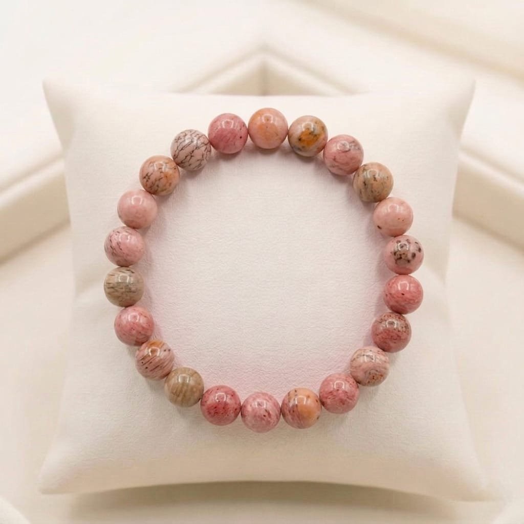 Natural Rhodochrosite crystal bracelet featuring polished raspberry-pink beads with white zig-zag bands from lakshya gems
