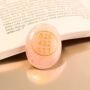 Natural Rose Quartz Zibu coin with engraved gold-toned love and gratitude symbol.