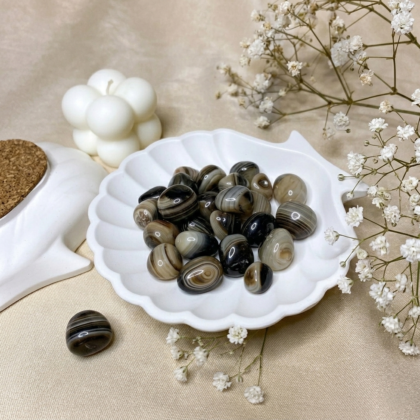 A collection of polished Sulaimani Agate crystal tumbles showing natural bands of black, white, and translucent grey.