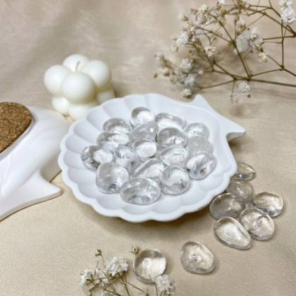 A collection of polished Clear Quartz crystal tumbles featuring high transparency and brilliant light reflection.