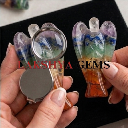 7 chakra crystal Angel from Lakshya Gems Mumbai A hand-bonded Seven Chakra crystal angel featuring layers of natural red, orange, yellow, green, blue, indigo, and violet gemstones.