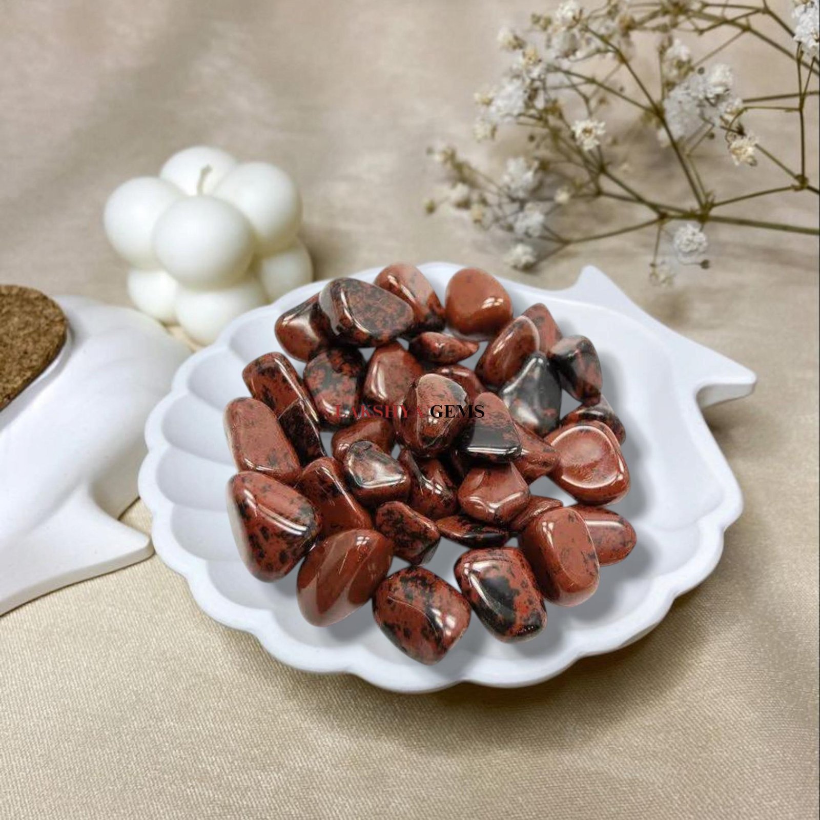 A collection of polished Mahogany Obsidian crystal tumbles featuring deep black glass with reddish-brown earthy swirls.